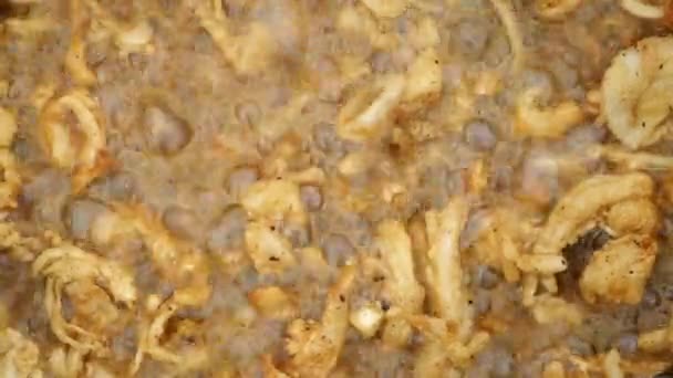 Fette di cipolla fresca friggere in olio bollente in calderone kazan nero, vista da vicino. — Video Stock