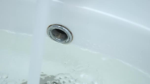 Dräneringshålet i diskhon är igensatt och vatten samlas upp från kranen. — Stockvideo
