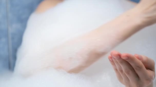 Mujer está aplicando aceite para la piel en su palma y frotándolo en el baño con espuma. — Vídeos de Stock