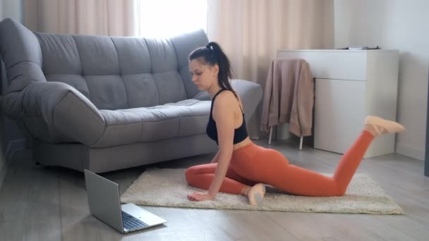 Jeune femme pratique le yoga faisant pose de pigeon à la maison formation en ligne. — Video