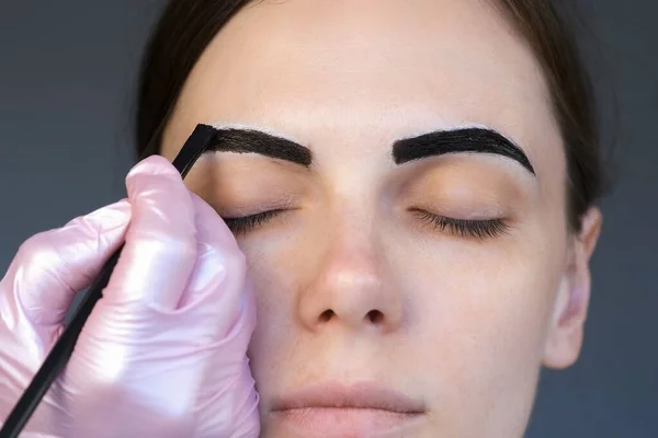 Косметолог рисует женские брови в косметологической клинике, крупным планом. — стоковое фото