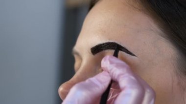 Kozmetik uzmanı kozmetoloji kliniğinde kadınların kaşlarını boyuyor..