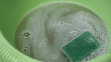 Kirli köpüklü su ve kirli sünger havzada elle yıkanır..