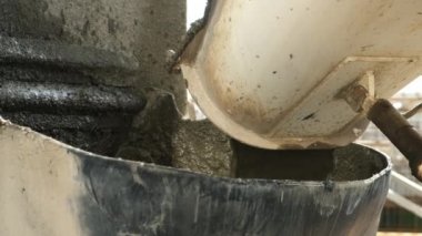 İnşaat alanındaki metal konteynerin içindeki betondan dökülen beton..