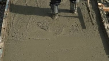 İnşaat işçisi inşaat sahasında beton döşeyen uzun malalı inşaat işçisi.