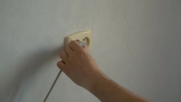 Mans mão transforma os garfos plugues de um aparelho elétrico em uma tomada. — Vídeo de Stock