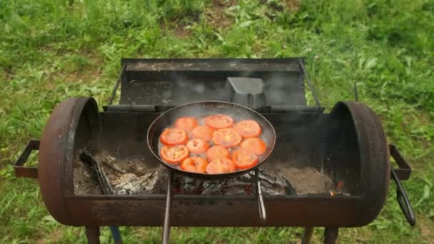 Tomatenscheiben braten auf Pfanne mit Öl im Holzkohlegrill, Draufsicht. — Stockvideo
