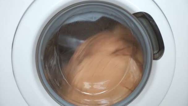 Tvättmaskin med beige sänglinne inne fungerar, tvätt hemma. — Stockvideo