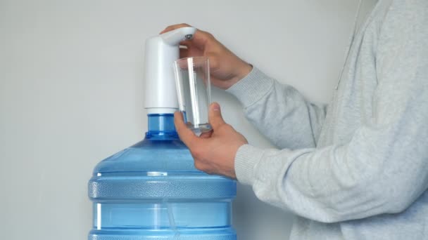 Mans kezét öntsük vizet az üvegbe egy automatikus vízhűtő, közelről. — Stock videók