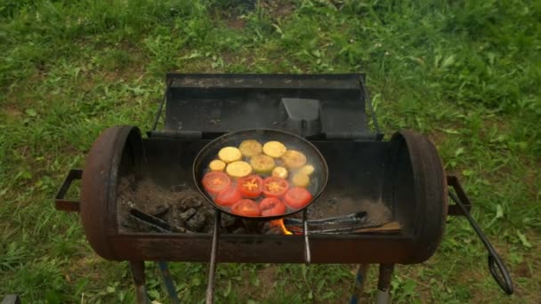 Fatias de abobrinha e tomate estão fritando na frigideira com óleo em chargrill. — Vídeo de Stock