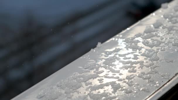 Ανοιξιάτικες σταγόνες και λιωμένο χιόνι στο περβάζι του παραθύρου έξω από το παράθυρο, κοντινό πλάνο. — Αρχείο Βίντεο