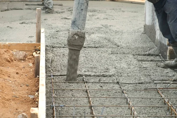 Man is pouring foundation with wet heavy concrete through pipe, closeup view. — Stock Photo, Image