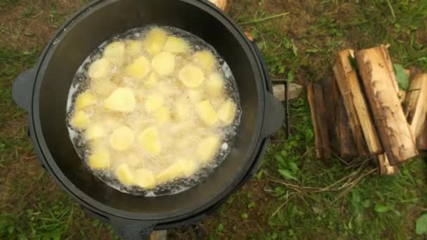 Potatis steks i kittel i olja på naturen i brand, närbild ovanifrån. — Stockvideo