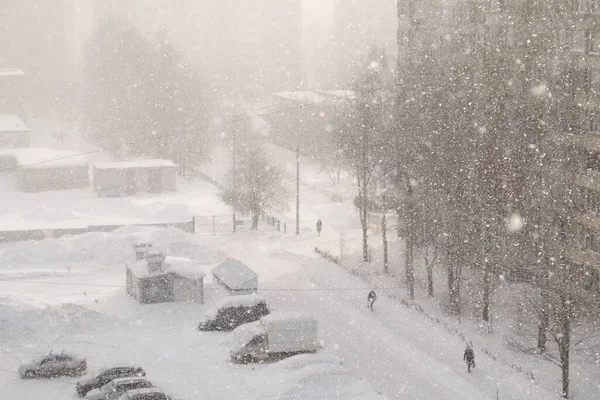 Городской пейзаж в синих тонах в сильный снегопад, метель, снежная буря на улице. Лицензионные Стоковые Изображения