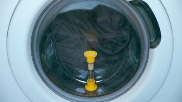 Sandglas på fönster av tvättmaskin med överkast inne, tvätt hemma. — Stockvideo