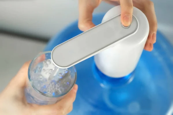 Женские руки наливают воду в стекло из автоматического кулера, вид крупным планом. — стоковое фото