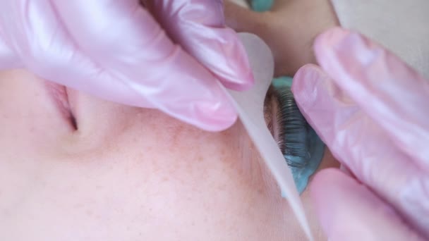 Cosmetoloog het aanbrengen van ooglapje onder klanten vrouw oog op het optillen van wimpers. — Stockvideo