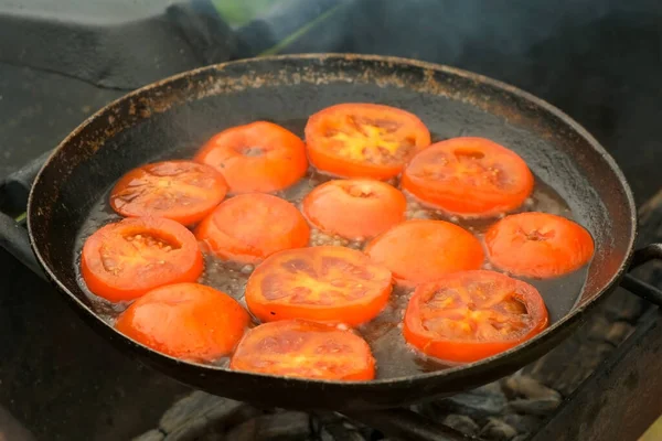 Slices of tomates is frying on frying pan with oil in grill, top view. — Stock Photo, Image