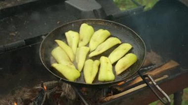 Yeşil biber dilimleri ızgarada yağlı tavada kızarıyor..