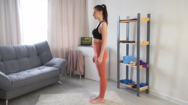 Jeune femme pratique la pose guerrière III virabhadasana faire du yoga à la maison. — Video