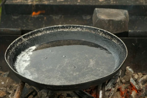 Frying pan with hot boiling oil on coals in the grill is ready for cooking. — Stock Photo, Image