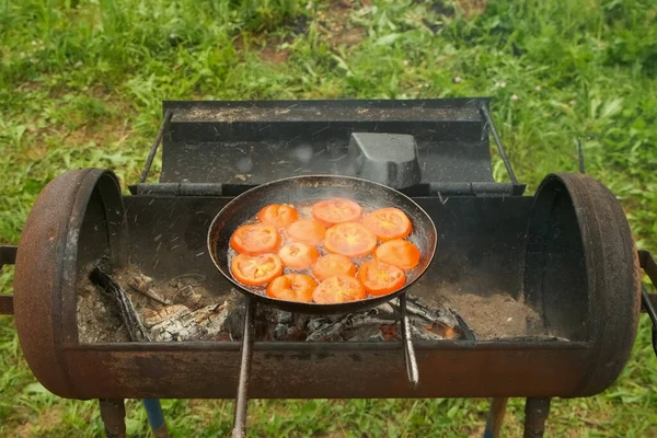 Slices of tomates is frying on frying pan with oil in chargrill, top view. — Stock Photo, Image
