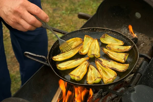 Κομμάτια πράσινου πιπεριού τηγανίζονται σε τηγάνι με λάδι σε κάρβουνο στη φύση. — Φωτογραφία Αρχείου
