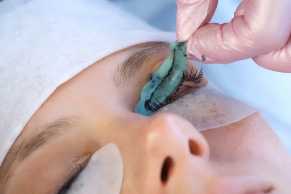 Kosmetikerin zieht Lockenwickler nach Wimpernheben vom Augenlid ab. — Stockfoto
