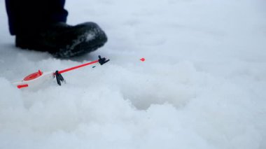 Aksiyon halindeki balıkçıların balık tutması soğuk sulardan olta çıkartır. Balık tutma yarışması. Donmuş nehir yüzeyinde bir adam. Açık havada kış etkinliği hobi eğlence sporu gibi bir şey..