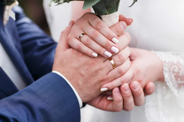 Bride and groom holding hands outdoors — Stock Photo, Image