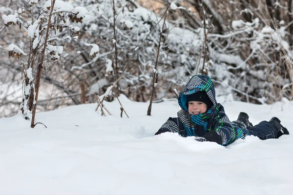 El niño en el bosque en invierno . — Foto de Stock