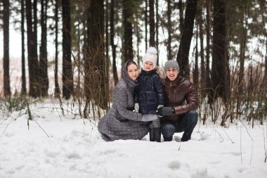 Mutlu aile bir kış parkta yürüyüş.
