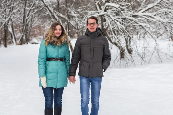 Jovem casal bonito andando na floresta de inverno — Fotografia de Stock