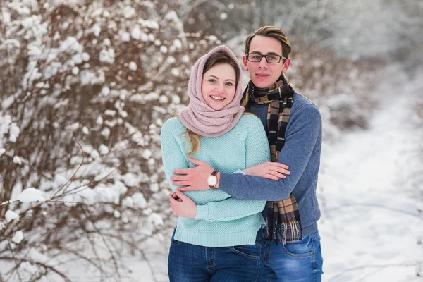 Jovem casal bonito andando na floresta de inverno — Fotografia de Stock