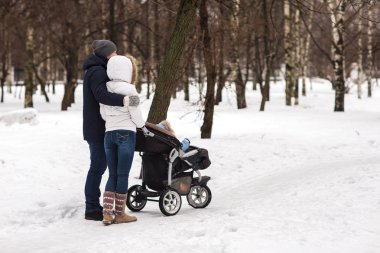 Mutlu genç aile kışın parkta yürüyüş