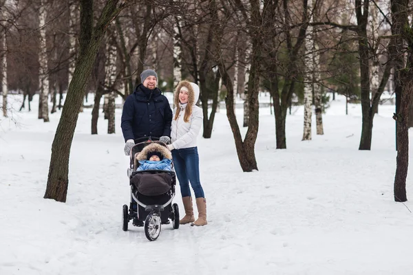 Happy young family walking in the park in winter — Stock Photo, Image
