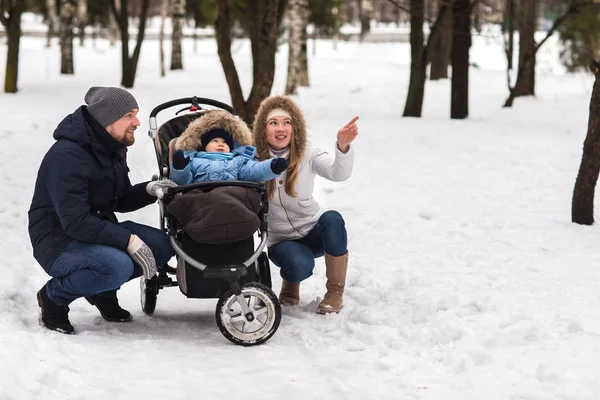 Feliz familia joven caminando en el parque en invierno — Foto de Stock