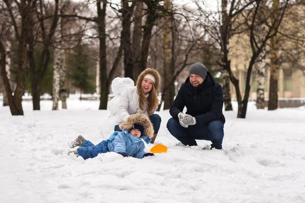 Счастливая молодая семья, гуляющая в зимнем парке — стоковое фото