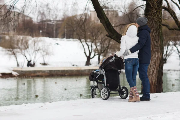 Mutlu genç aile kışın parkta yürüyüş