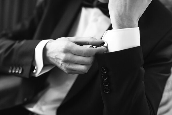 Confident man buttons cufflinks.