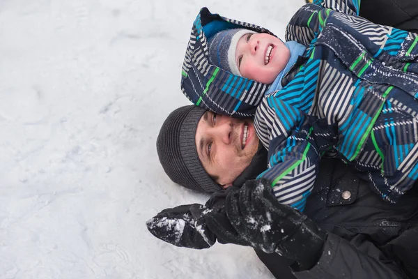 Um jovem com um menino alegre com um passeio de montanha-russa em th — Fotografia de Stock