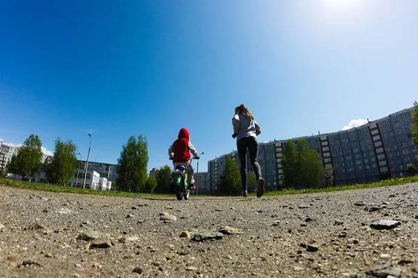 Mother and son run around the stadium — Stock Photo, Image