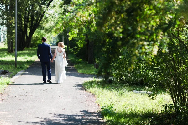 Lyckliga bruden och brudgummen promenader i skogen sommaren. — Stockfoto