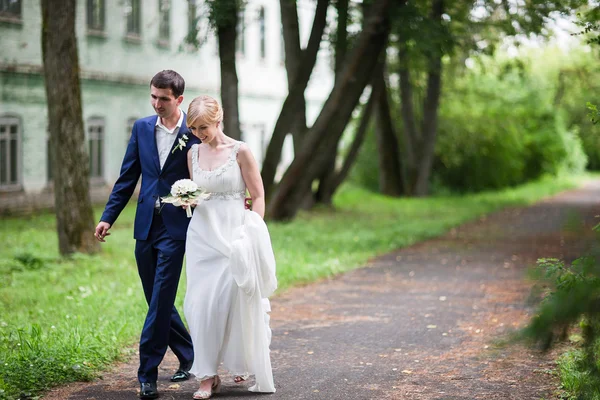 Happy bride and groom walking in the summer forest. — Stock Photo, Image