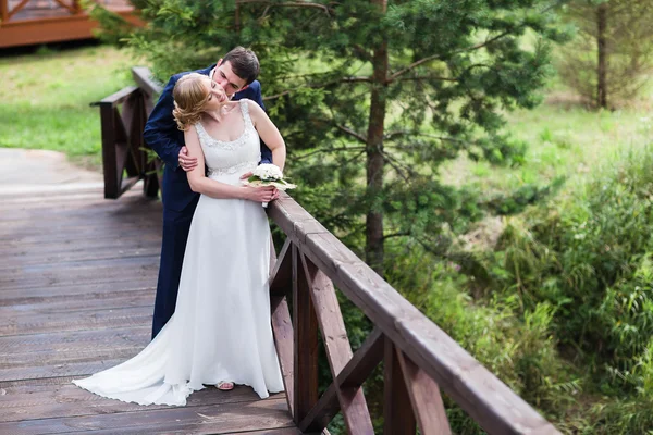 Happy bride and groom walking in the summer forest. — Stock Photo, Image