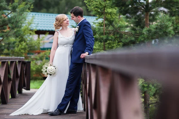 Happy bride and groom walking in the summer forest. — Stock Photo, Image