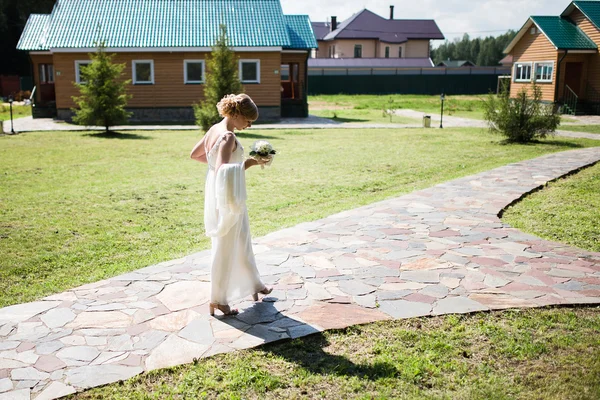 Glückliche Braut im Brautkleid dreht sich. — Stockfoto