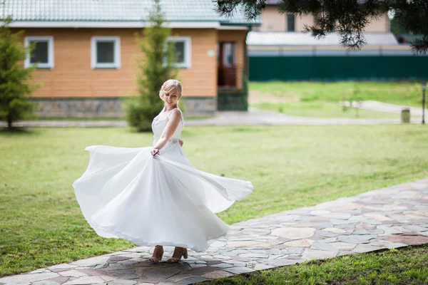 Happy bride in a wedding dress is spinning. — Stock Photo, Image