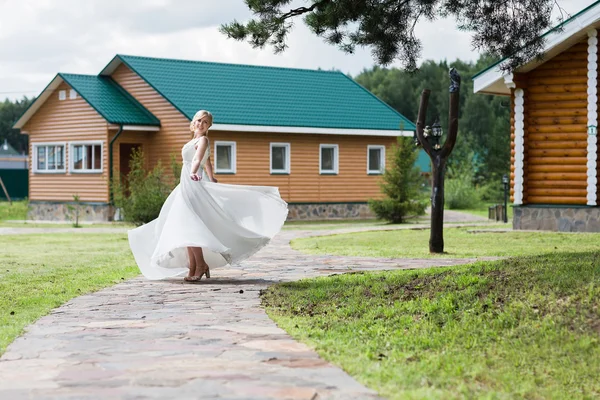 Happy bride in a wedding dress is spinning. — Stock Photo, Image