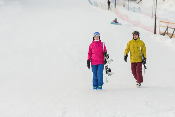 Junges Snowboardpaar geht mit Brettern spazieren — Stockfoto